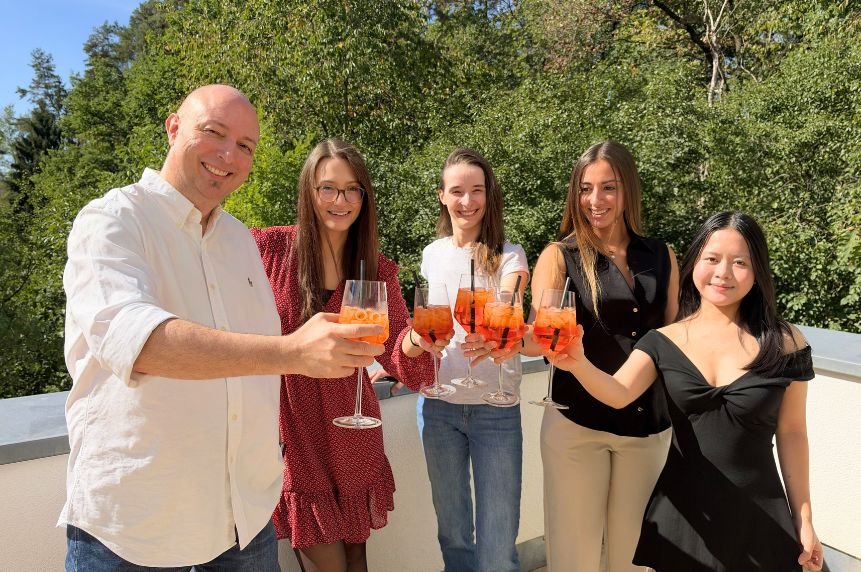 Das Team stößt auf der Terrasse gemeinsam an